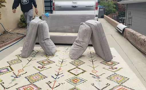 Concrete animal sculpture on a tiled walkway, with a person in the background.